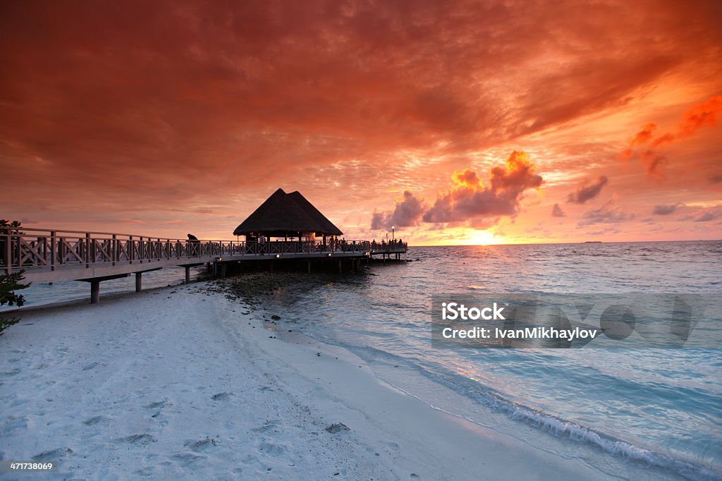 Case spiaggia tropicale al tramonto - Foto stock royalty-free di Acqua