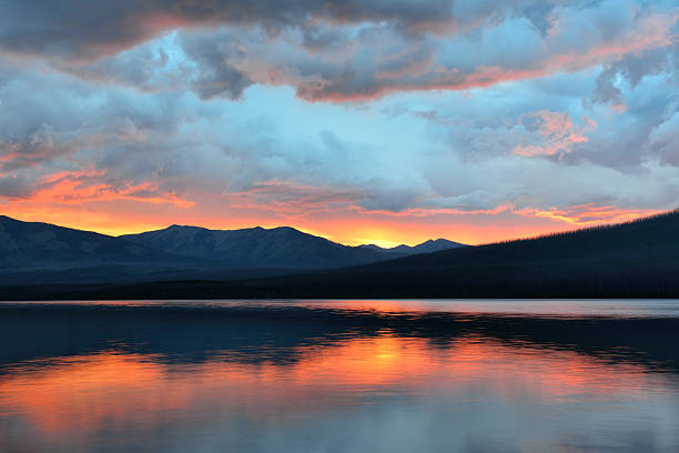 istock beautiful red sunset into the Mountains and McDonald lake 471738182