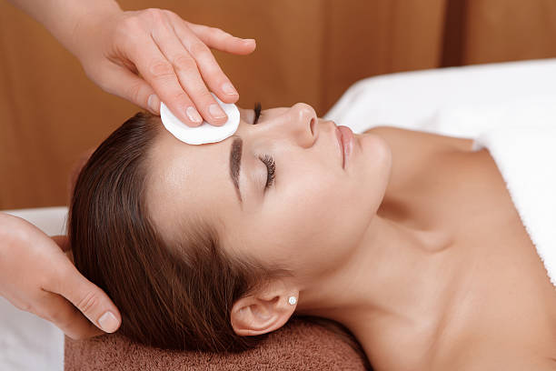 istock Beautician cleanses face of a client 471738788