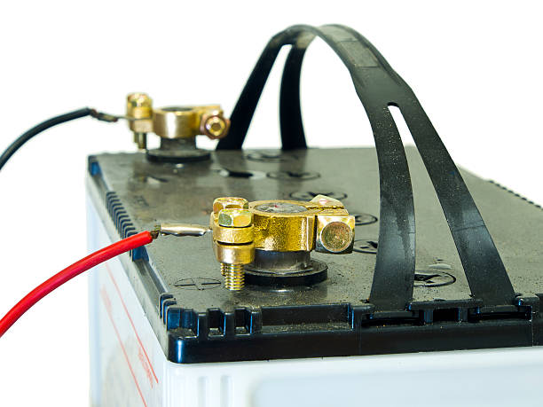 Close-up of a red car battery with bolts and nuts.