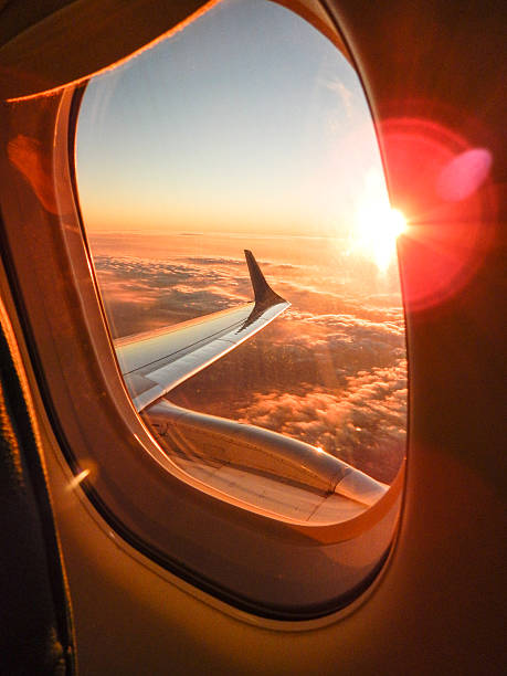 luce del sole dall'oblò in aereo - wing airplane window sunset foto e immagini stock