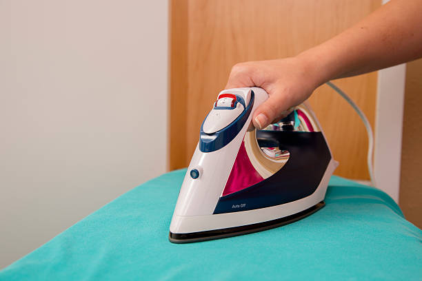 istock Domestic Lifestyle:  Young woman pressing blouse on the ironing board. 471740957
