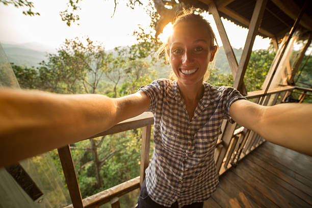 istock Happy young woman taking a selfie up in tree house 471740984