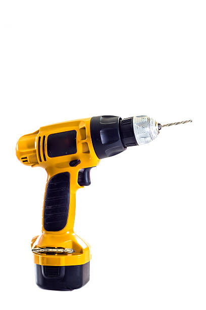 istock hand holding battery drill and drills wooden board, isolated 471741017