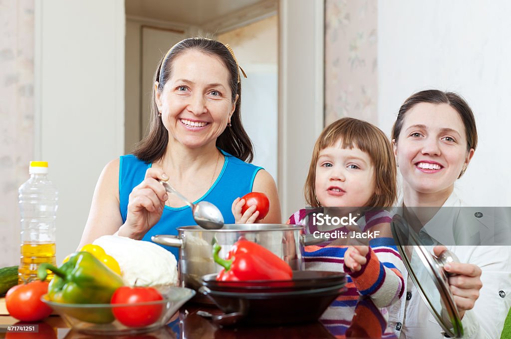 Mulher com criança cozinhar legumes almoço - Foto de stock de 50 Anos royalty-free