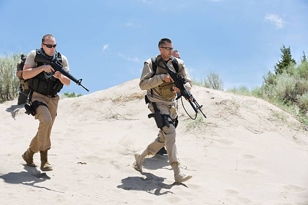 istock Military soldiers in uniform running through desert area 471741261
