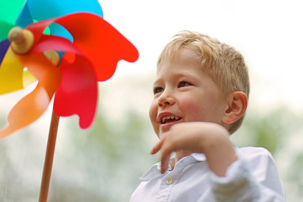 istock Cheerful Boy Turning the Colorful Pinwheel 471744676