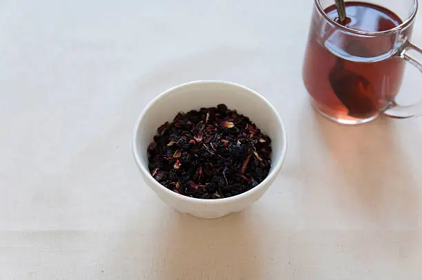 Dried Herbs and Fruits Preaparation in a bowl and Herbal Tea in a cup.