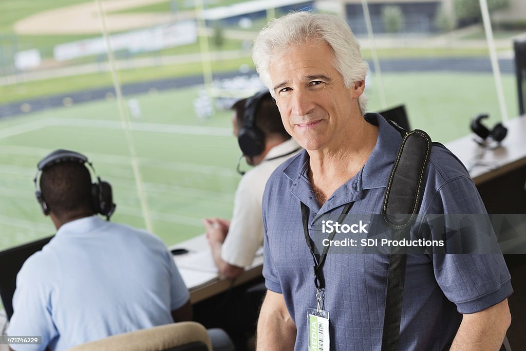 Sports journalist reporting from press box at stadium Active Seniors Stock Photo