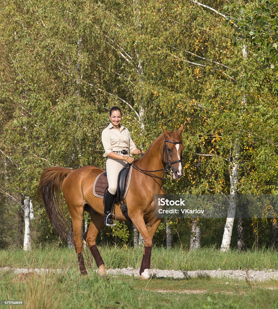 Jeune femme chevauchant un cheval à travers la forêt - Photo de Adolescent libre de droits