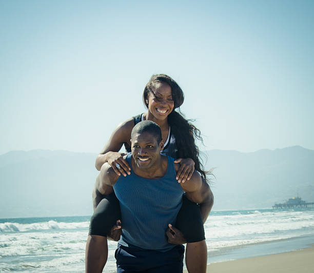 istock Young couple piggyback on the beach 471747847