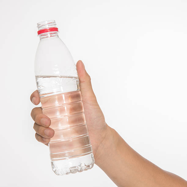 istock Hand holding bottle of water isolated on white. 471748021