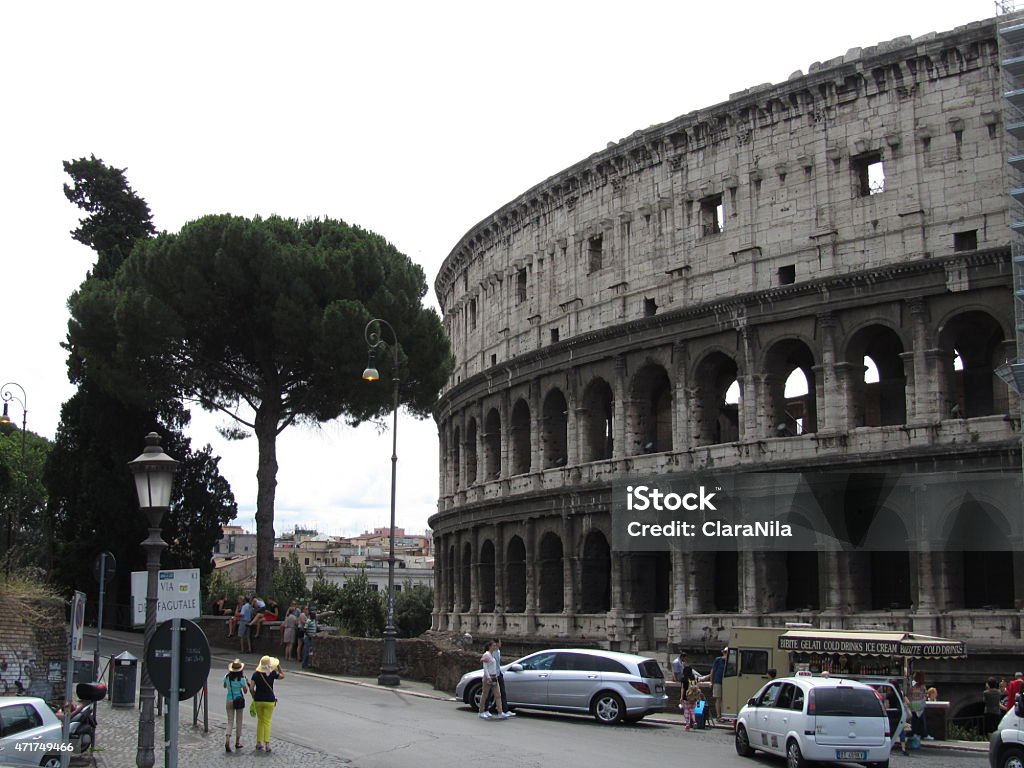 Colosseum amphitheater in Rome, Italy Colosseo Colosseum the amphitheater in Rome, beautiful capital Rome in Italy under blue sky with white clouds, it is summer time for holidays and many tourists, there is a lot of history to experience the amphitheater, the ancient architecture of the Arena, the famous Colosseum, the historic Roman Forum, the stretchy staircase and the Trevi Fountain are attractions and a sight of ancient culture and ornate art,  the river Tiber ItalianTevere is the pride of every Roman, the Catholic Church shows itself in Rome with St. Peter's Basilica, Roman ancient basilica, basilica papale di san pietro in vaticano, the castel sant'angelo, the cathedral church, valuable history and heritage of the people, dome characterize the urban landscape of Rome 2015 Stock Photo