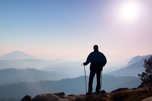 istock Man hiker legs in boots and poles stand on mountain 471749534