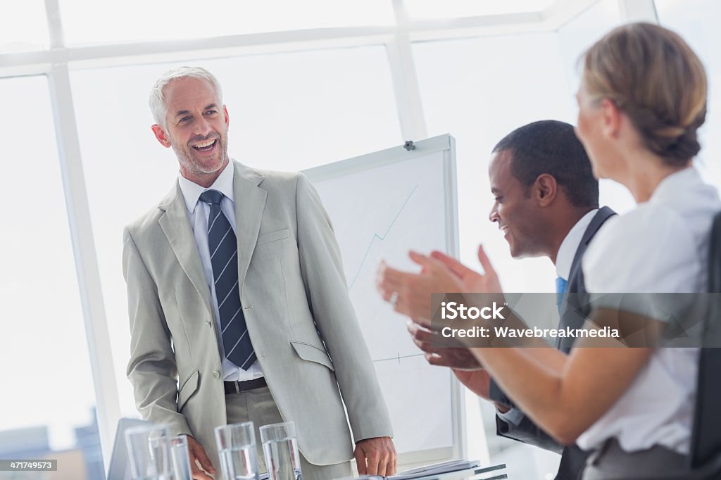 Współpracownikami Oklaskiwać uśmiech menedżer podczas spotkania - Zbiór zdjęć royalty-free (Biurko)