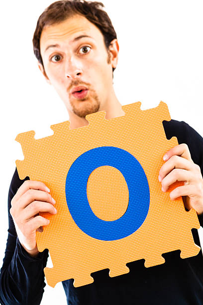 istock Young Man Playing with Alphabet Puzzle, Letter O 471749827
