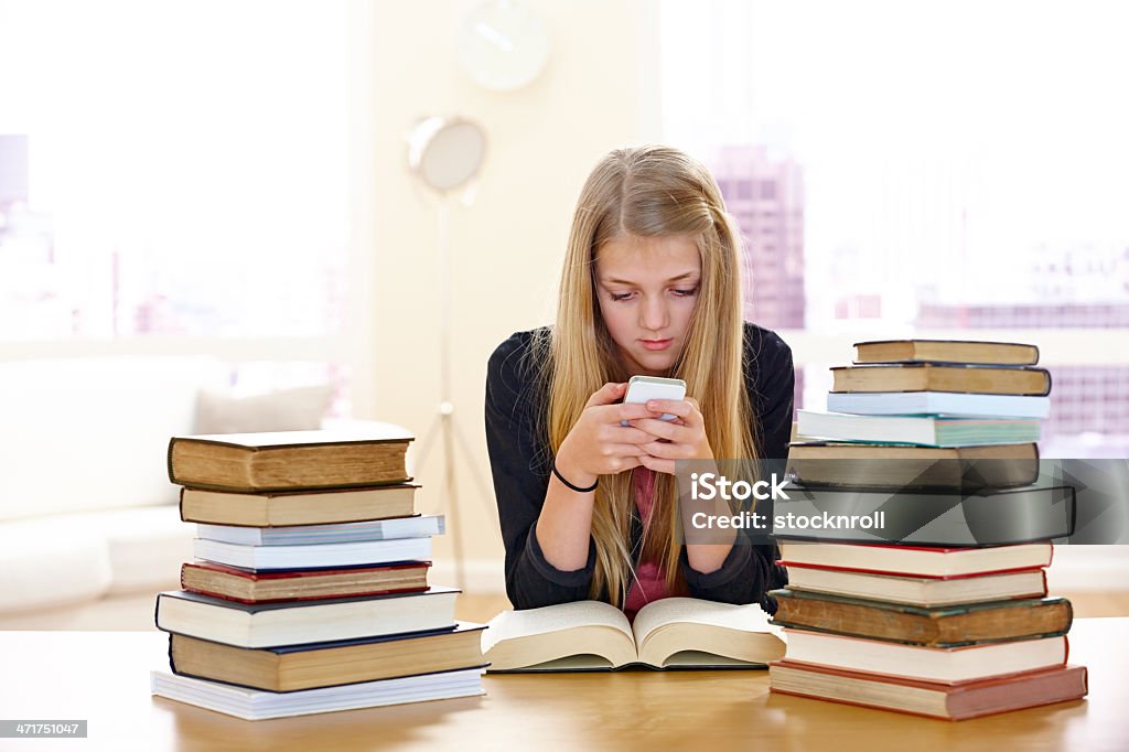 Mignonne petite fille à envoyer des SMS, et étudier - Photo de Adolescence libre de droits