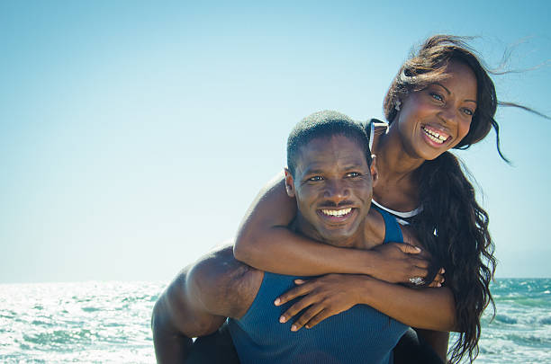 istock Young couple piggyback on the beach 471752879