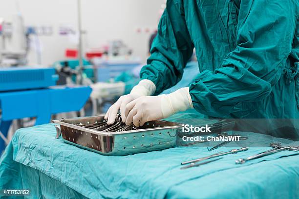 Scrub Nurse Preparing Medical Instruments For Operation Stock Photo - Download Image Now