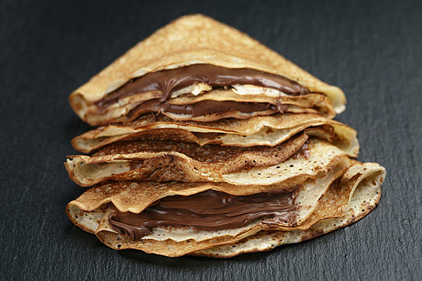 istock thin crepes or blinis with chocolate cream on slate board 471753366