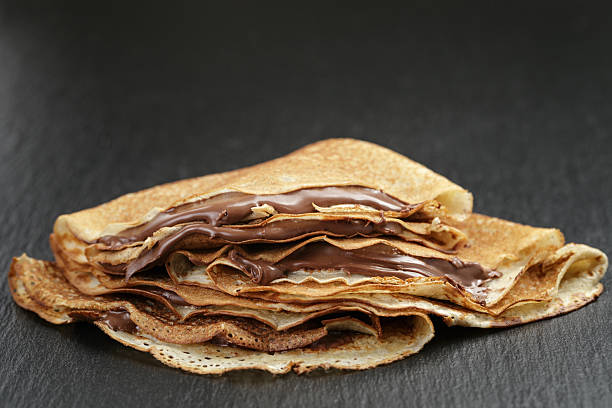 istock thin crepes or blinis with chocolate cream on slate board 471753380