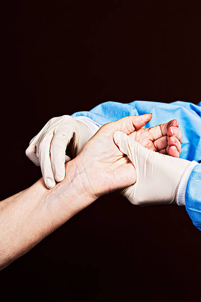 istock Gloved medical professional takes elderly patient's pulse 471753711