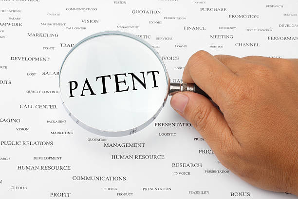 Looking for patent. The word PATENT is magnified. patent search stock pictures, royalty-free photos & images
