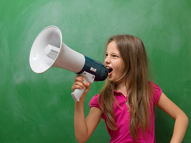 istock Little girl  Shouting With Megaphone before blackboard 471754871