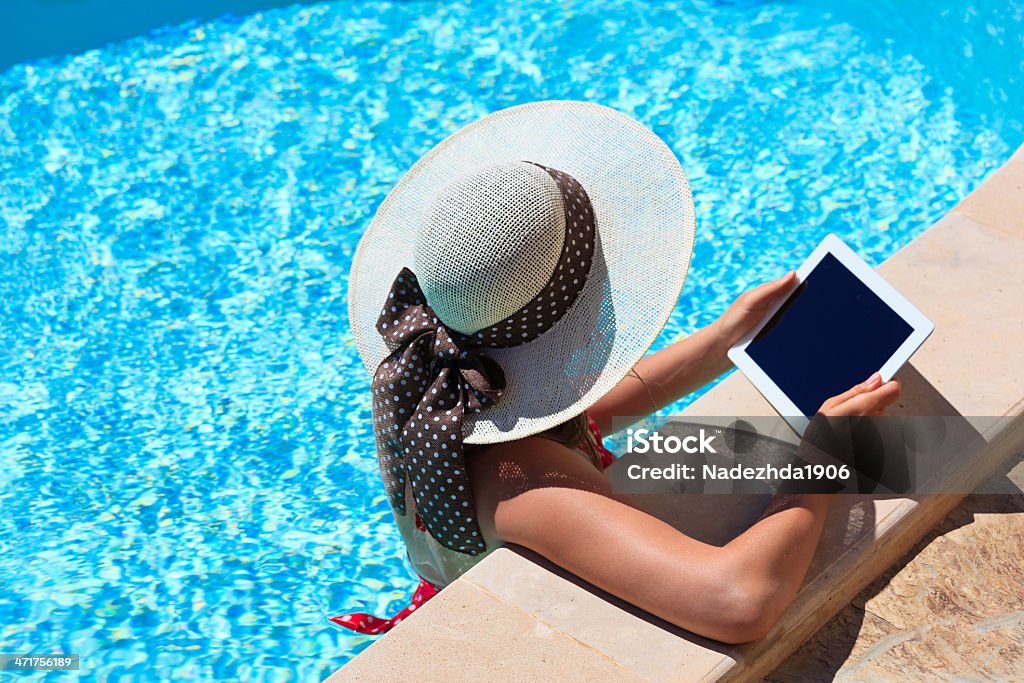 young woman with touch pad on vacation young woman with touch pad on vacation. Working on holiday concept Digital Tablet Stock Photo