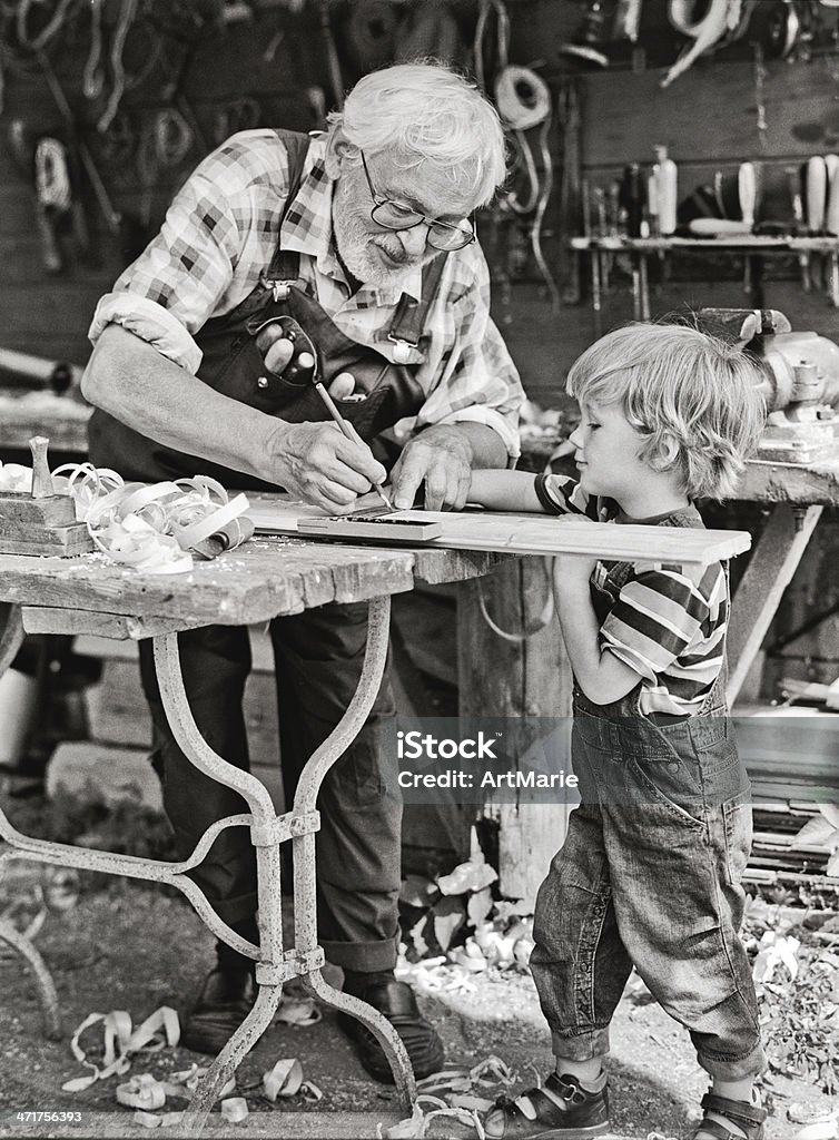 Grand-père et son petit-fils en atelier - Photo de Atelier de menuiserie libre de droits