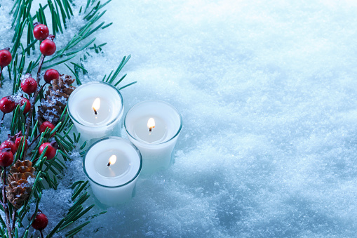 Christmas boughs with snow and candles.