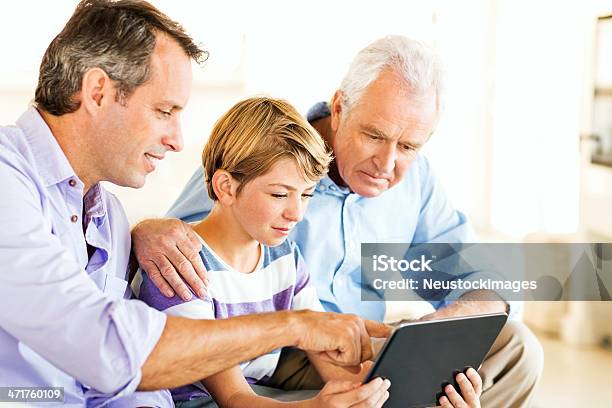 Nieto Con Padre Y Abuelo Usando Tableta Digital En Su Hogar Foto de stock y más banco de imágenes de 10-11 años
