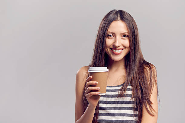 istock Woman drinking hot drink from disposable paper cup 471760450