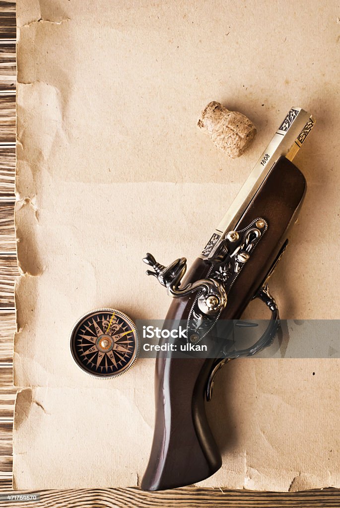 Compass and pistol on the old paper background 2015 Stock Photo
