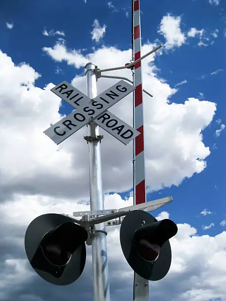 Railroad crossing sign with lights and barrier
