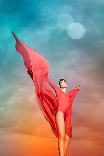 istock Beautiful woman with red chiffon in front of cloud background 471765151