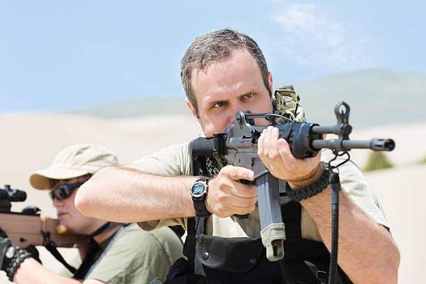 istock Military soldiers aiming weapons in desert during combat 471765279