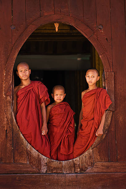 istock Novice Buddhist monks looking out of the window 471765533