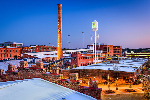 Durham, North Carolina Downtown at Dusk Durham, North Carolina, USA - April 27, 2015: The American Tobacco Historic District. Once the headquarters of the American Tobacco Company, the site is now part of a downtown urban renewal project. durham north carolina stock pictures, royalty-free photos & images
