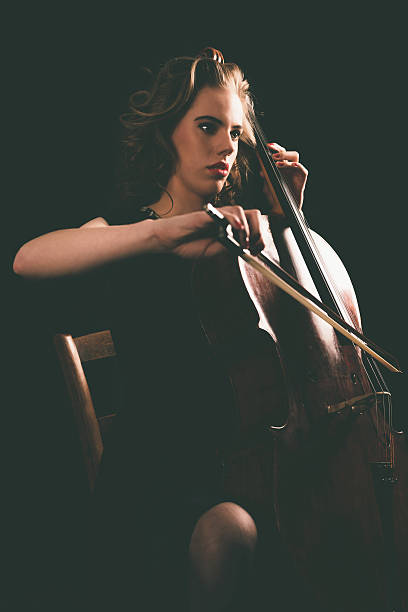 istock Sitting Young Woman Playing a Cello Instrument 471767086