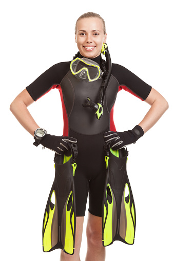 Young smiling blonde woman wearing a wet suit to swim with mask ,snorkel and fins ready to dive.