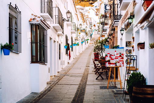 Mijas, Spain- January 5, 2014: Charming whitewashed narrow street In Mijas. Mijas is a lovely Andalusian white village on the Costa del Sol. It is popular touristic place, it is lined with cafes, restaurants and souvenir shops