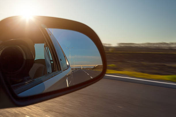 istock Rearview mirror and the setting sun from car 471767720