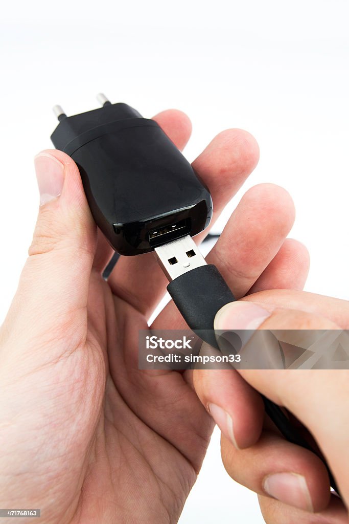 Homem usando o celular preto carregador USB - Foto de stock de Adaptador royalty-free