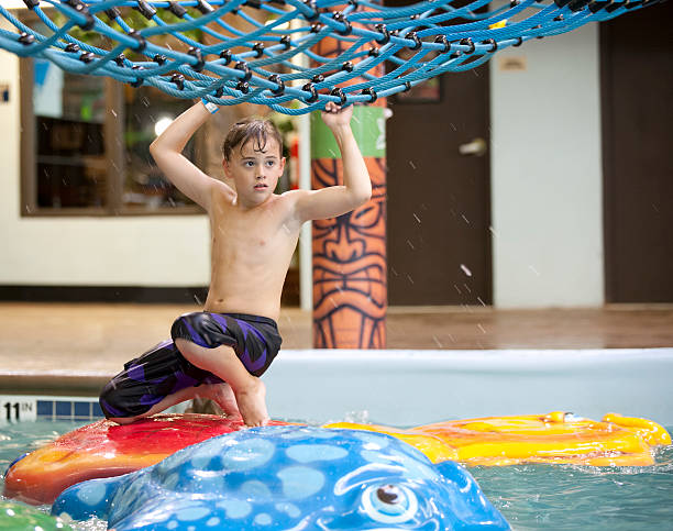 istock Young boy playing at the indoor water park 471768197