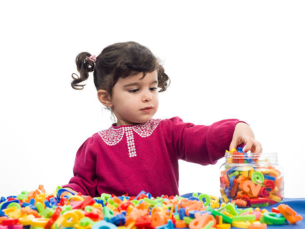 istock Little girl playing with letters 471768343