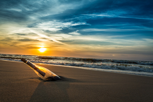 Message in a bottle on a sea shore.