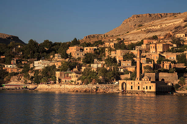 New halfeti houses behind the old mosque Halfeti,Turkey - August 27, 2013: Halfeti mosque  submerged in the 1990s under the waters behind the dam on the Euphrates at Birecik.  halfeti stock pictures, royalty-free photos & images