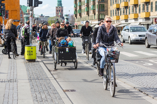 Copenhagen, Denmark - April 28, 2015: People going by bike in the city. A lot of commuters, students and tourists prefer using bike instead of car or bus to move around the city.