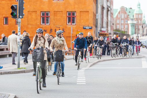 Copenhagen, Denmark - April 28, 2015: People going by bike in the city. A lot of commuters, students and tourists prefer using bike instead of car or bus to move around the city.